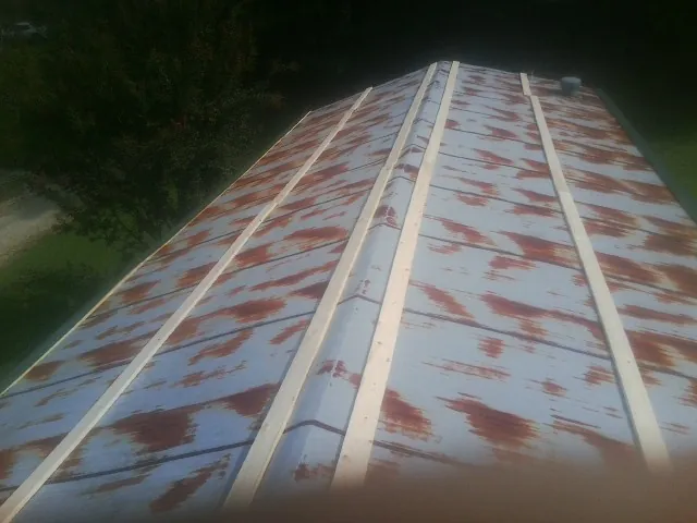 Rusted metal roof panels with new wood purlins before replacement — Storm Damage Roof Repair in Franklinville by Roofing Brothers