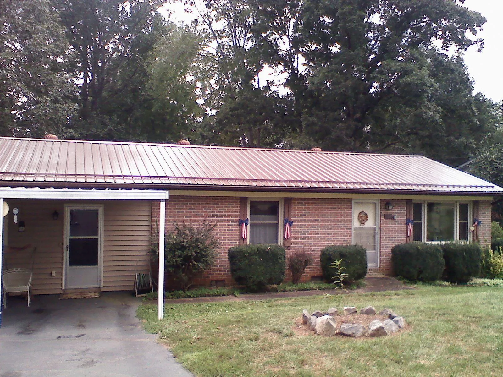 Bronze metal roof and carport on a brick ranch home — Roof Repair work by our crew in Franklinville
